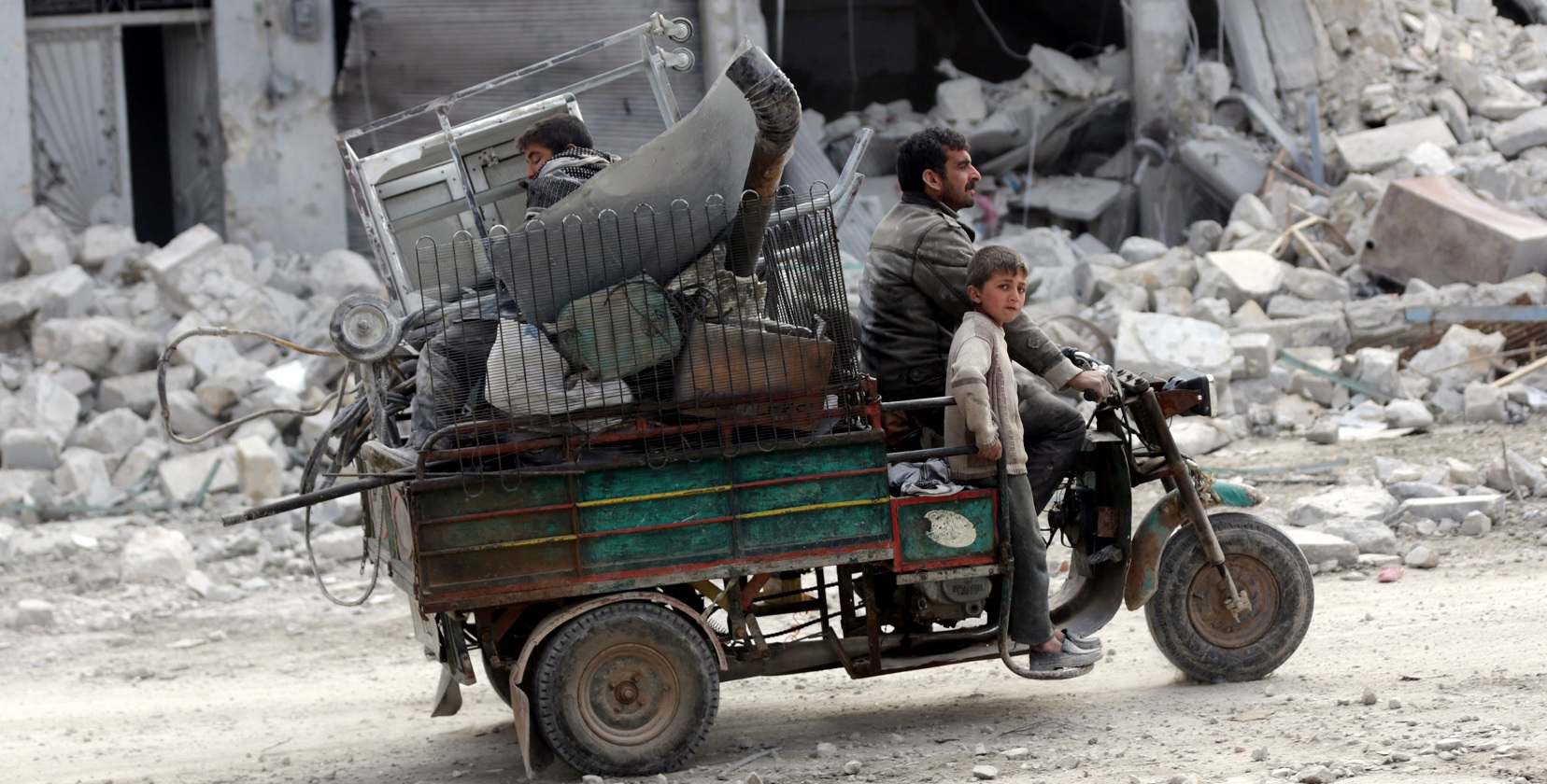 Una familia conduce un vehículo a través de un vecindario dañado en la ciudad siria del norte de al-Bab (Reuters)