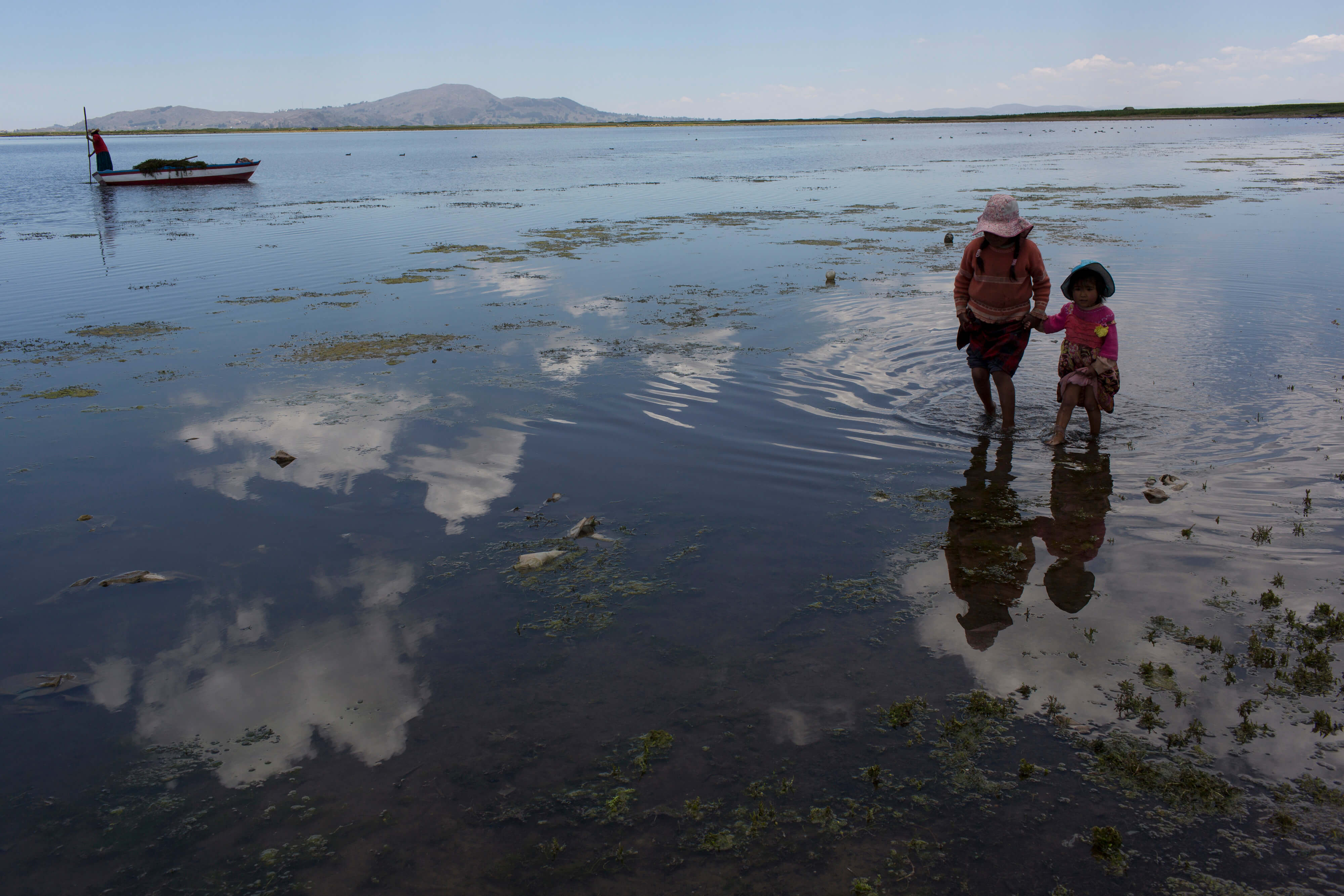 Estas personas buscan juguetes abandonados en la orilla del lago Titicaca, en Coata, Perú. Las orillas del lago están llenas de ranas muertas, cubos de pintura vacíos y bolsas de basura. (AP)