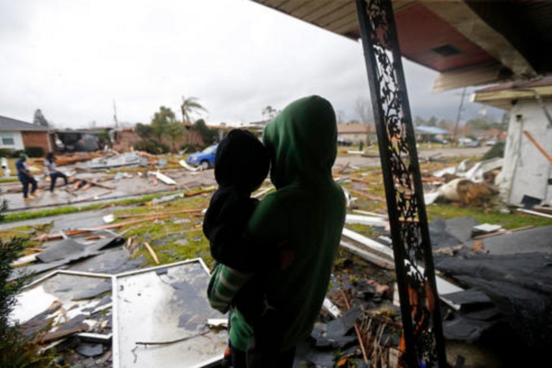 Eshon Trosclair sostiene a su hijo tras severas tormentas en el este de New Orleans, Estados Unidos (AP)