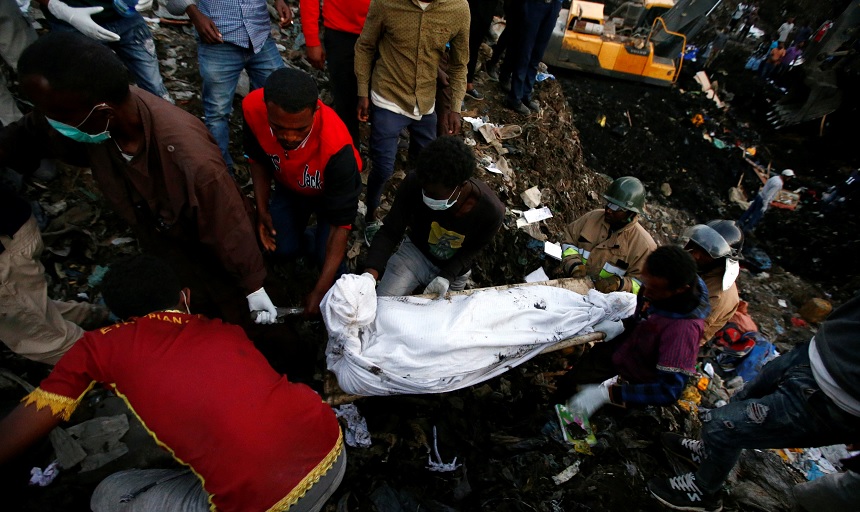 Trabajadores de rescate llevan el cuerpo de una víctima recuperada de un montón de basura después de un deslizamiento de tierra en la capital de Etiopía (Reuters)