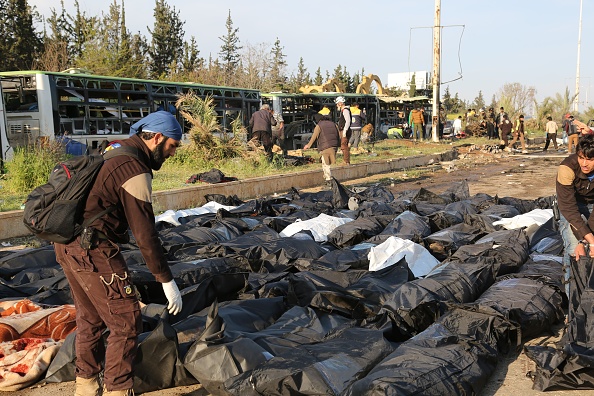 Miembros del equipo de defensa civil trasladan los cuerpos de las personas que murieron por un ataque con coches bomba contra un convoy de refugiados sirios (Getty Images)