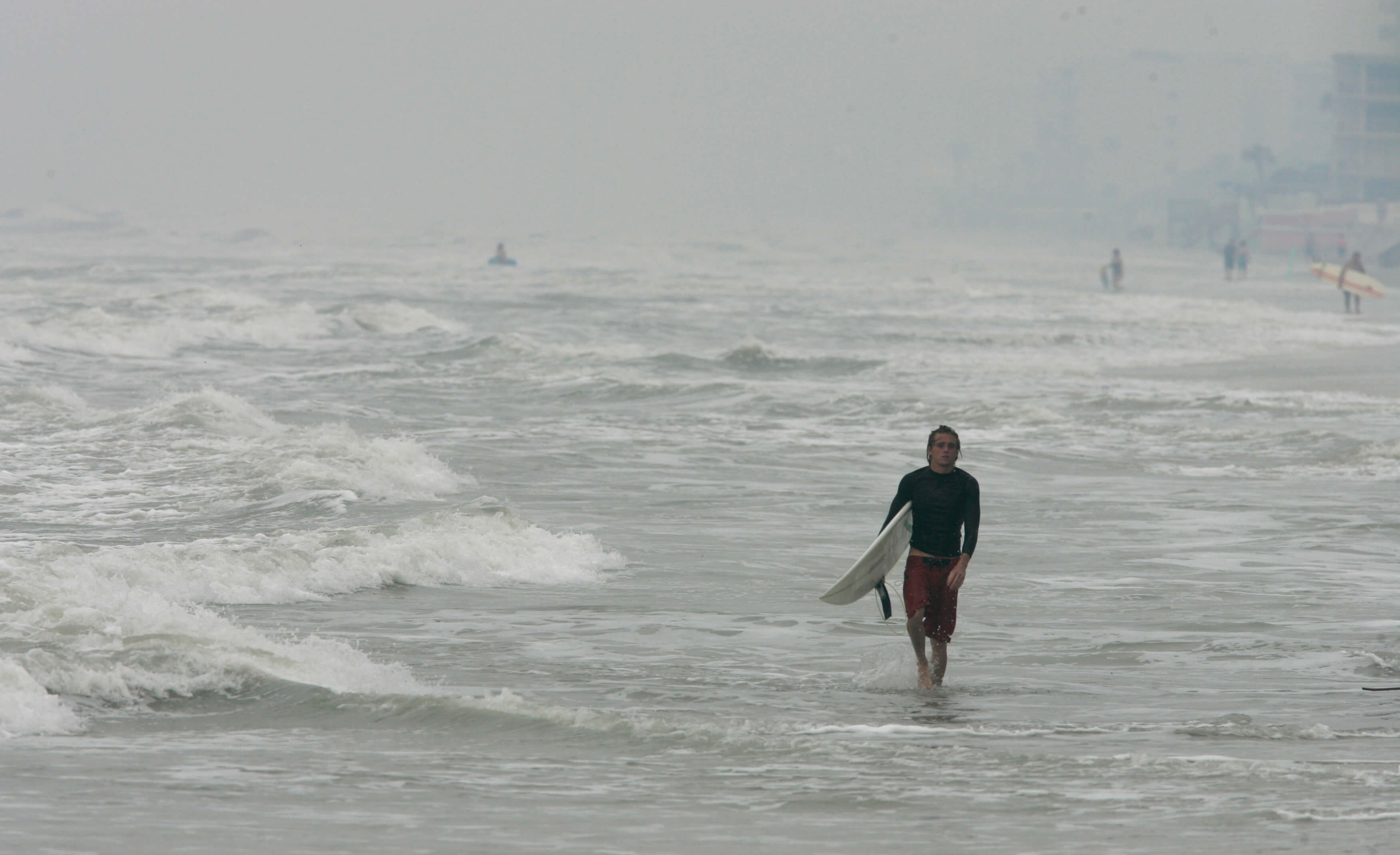 Un surfista camina a lo largo de la playa New Smyrna, en Florida. (AP/archivo)