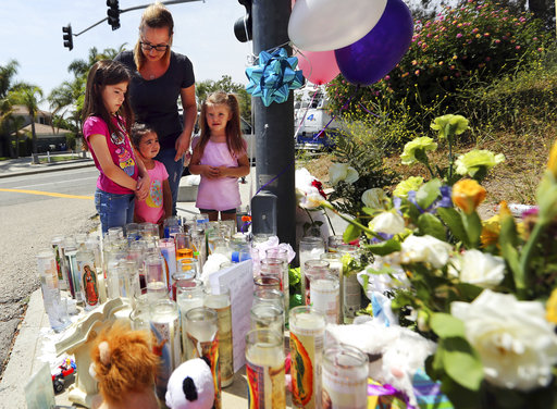 Algunas personas acudieron este martes para rezar y colocar flores en un memorial montado sobre la banqueta fuera de la escuela de San Bernardino, EU. (AP)