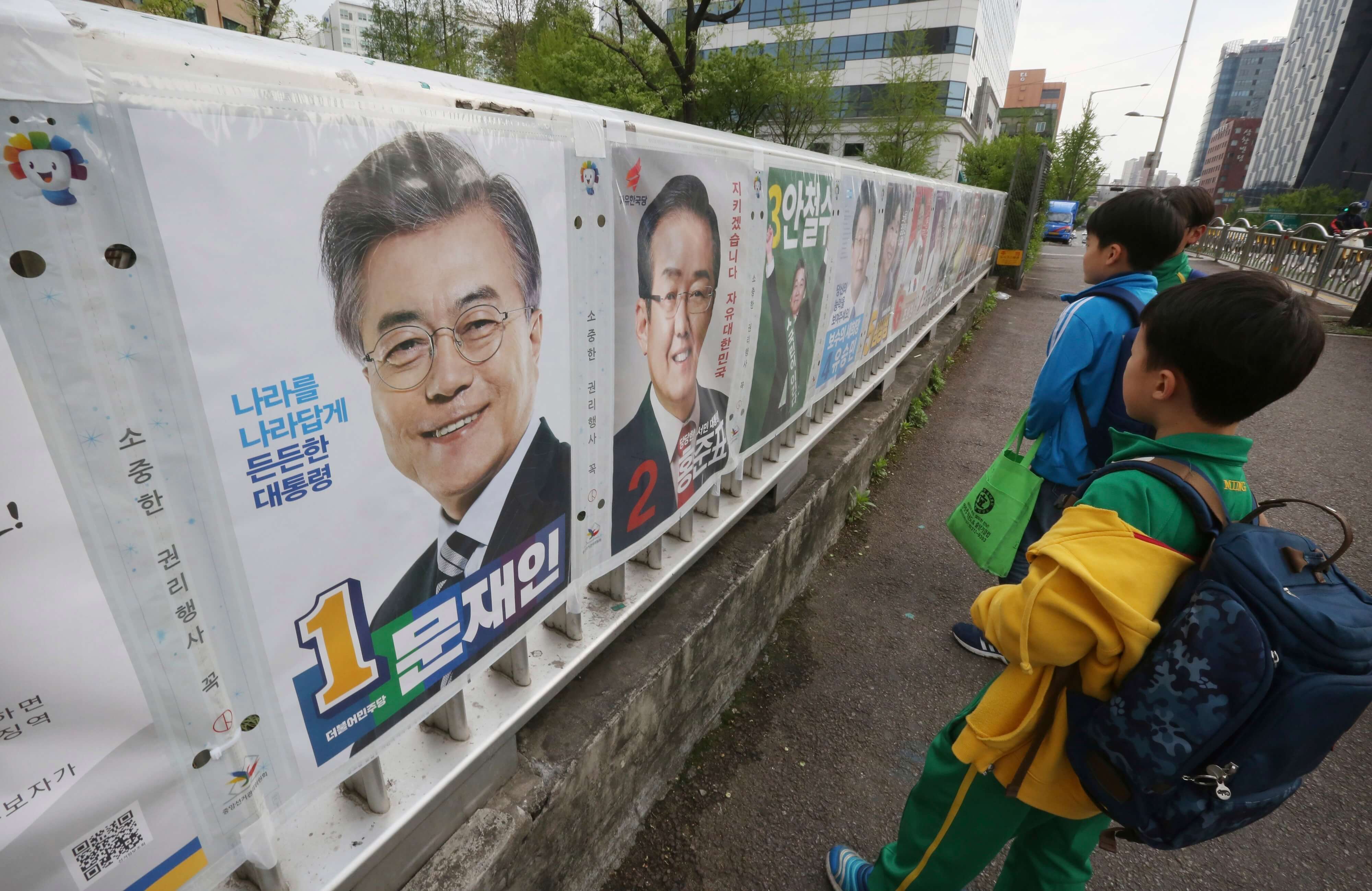 Los estudiantes de la escuela primaria miran los carteles que muestran a candidatos para la elección presidencial en Seúl, Corea del Sur. (AP)
