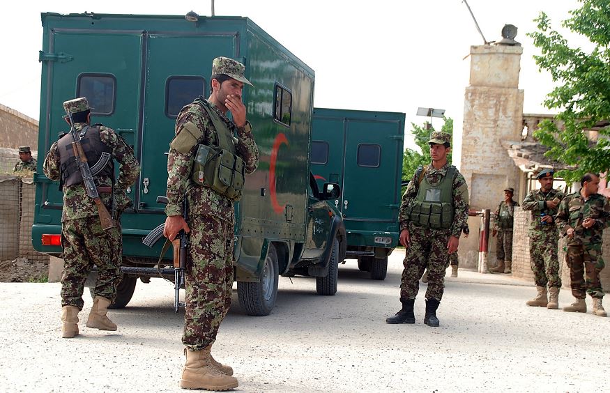 Militares afganos hacen guardia mientras las ambulancias entran a la base militar, lugar del ataque talibán. (AP)