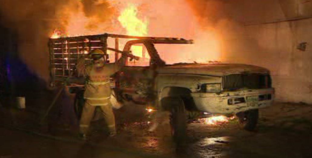 Un bombero combate el incendio de una camioneta en Monterrey (Noticieros Televisa)