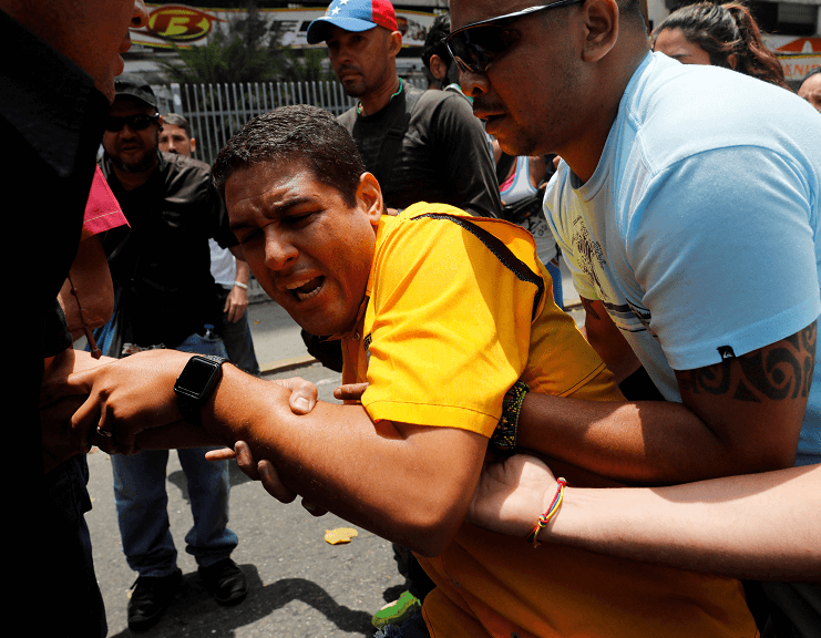 El diputado opositor venezolano José Manuel Olivares luego de ser alcanzado por los gases lacrimógenos. (Reuters)