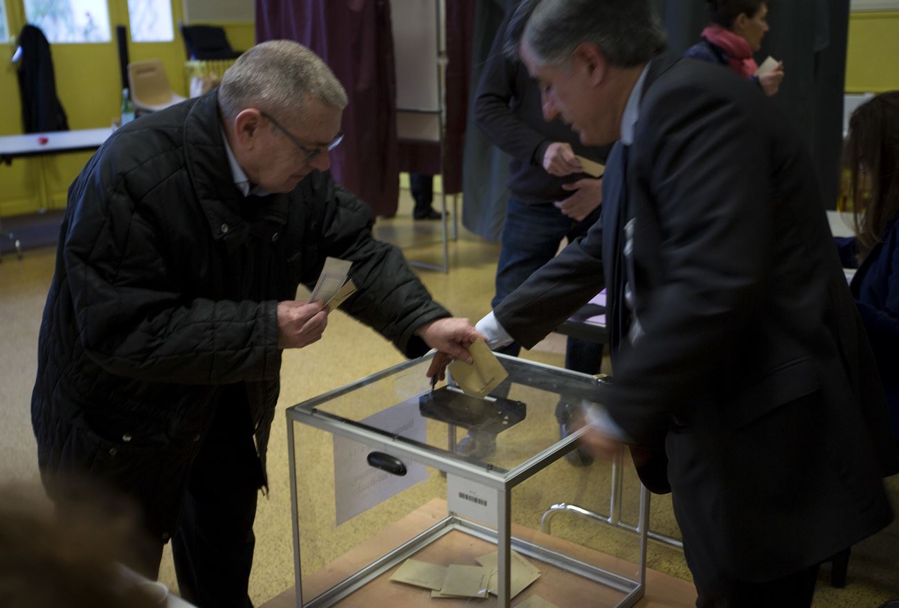 Un hombre deposita su voto en la primera vuelta de las presidenciales francesas. (AP)