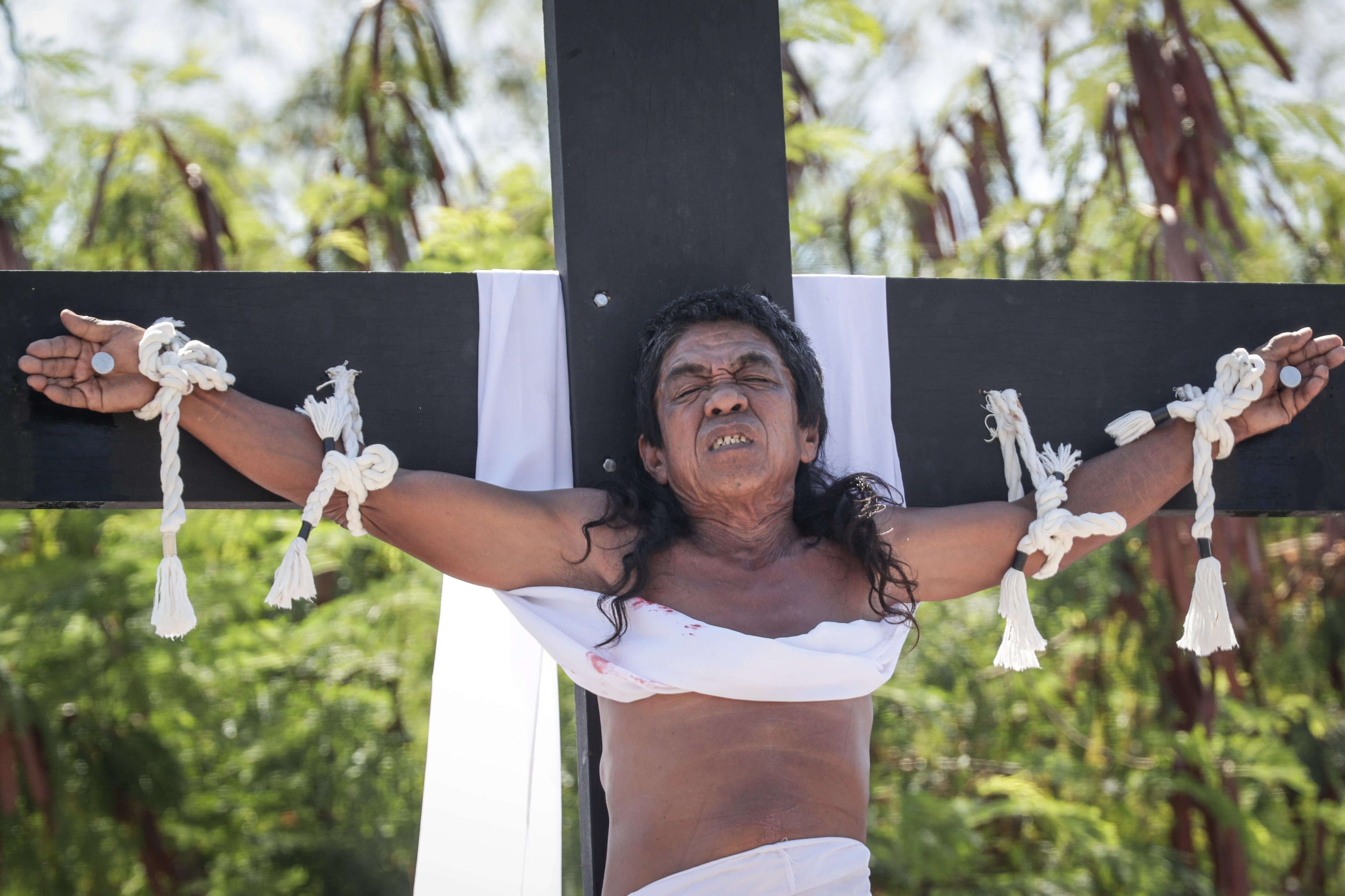 Un penitente filipino está clavado en la cruz durante la recreación de la crucifixión de Jesucristo el Viernes Santo en el pueblo de San Juan (EFE)