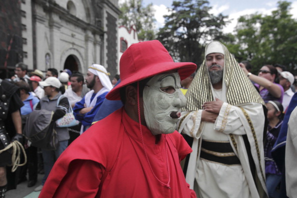 Personajes enmascarados y vestidos de rojo salen de la Iglesia de San Pablo Apóstol, en Cuajimalpa. (Getty Images)