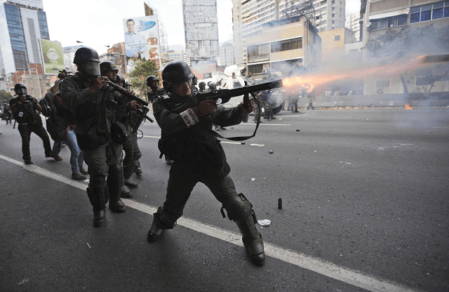 La Guardia Nacional Bolivariana de Venezuela lanza gases a los opositores durante una marcha. (AP)
