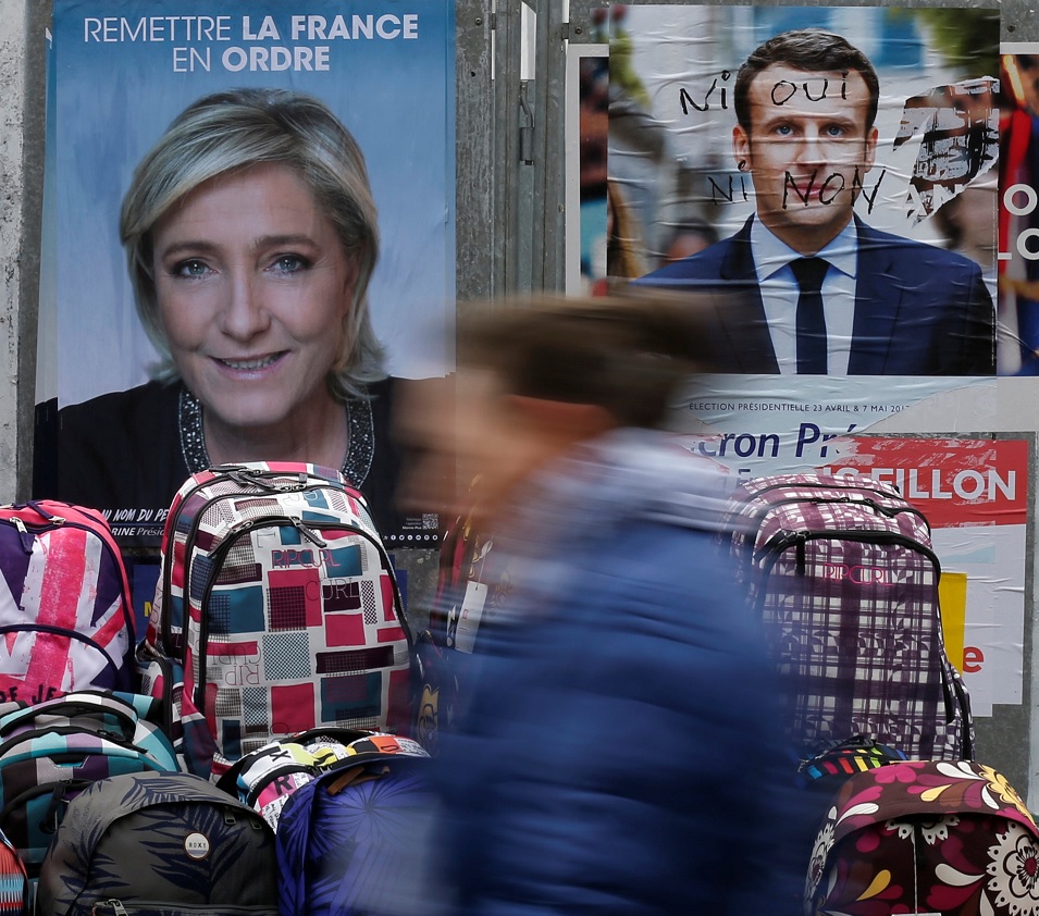 Una mujer recorre los carteles oficiales de los candidatos para la elección presidencial francesa de 2017 (Reuters)