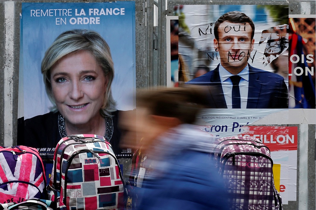 Carteles de Emmanuel Macron y Marine Le Pen, quienes disputarán la segunda vuelta presidencial (Reuters, archivo)