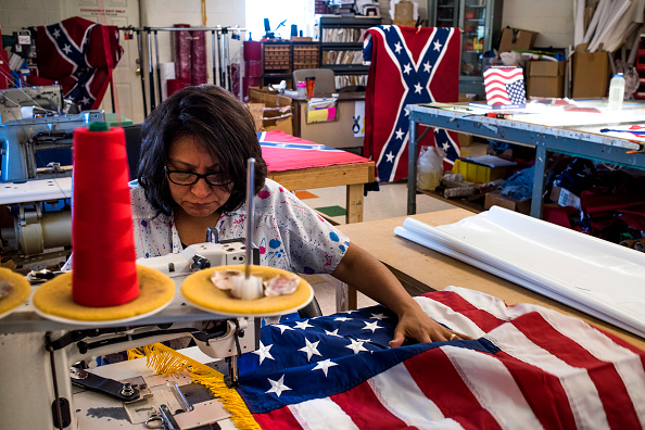 Obrera elabora una bandera de Estados Unidos; el sector manufacturero de ese país se expande durante marzo, pero en menor medida al mes anterior (Getty Images, archivo)