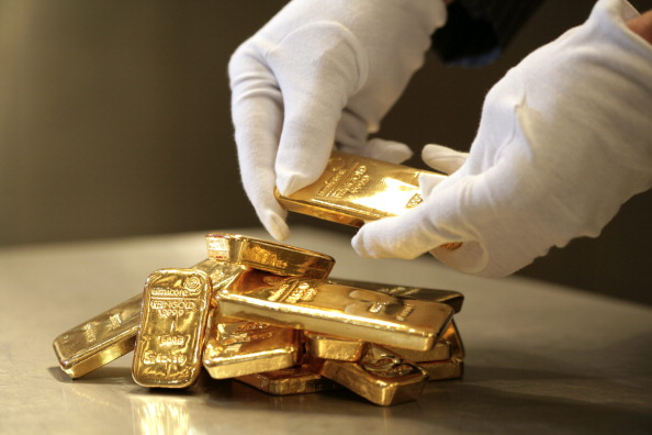 Persona apila lingotes de 500 y 1000 gramos de oro; el precio del metal desciende por fortaleza del dólar (Getty Images)