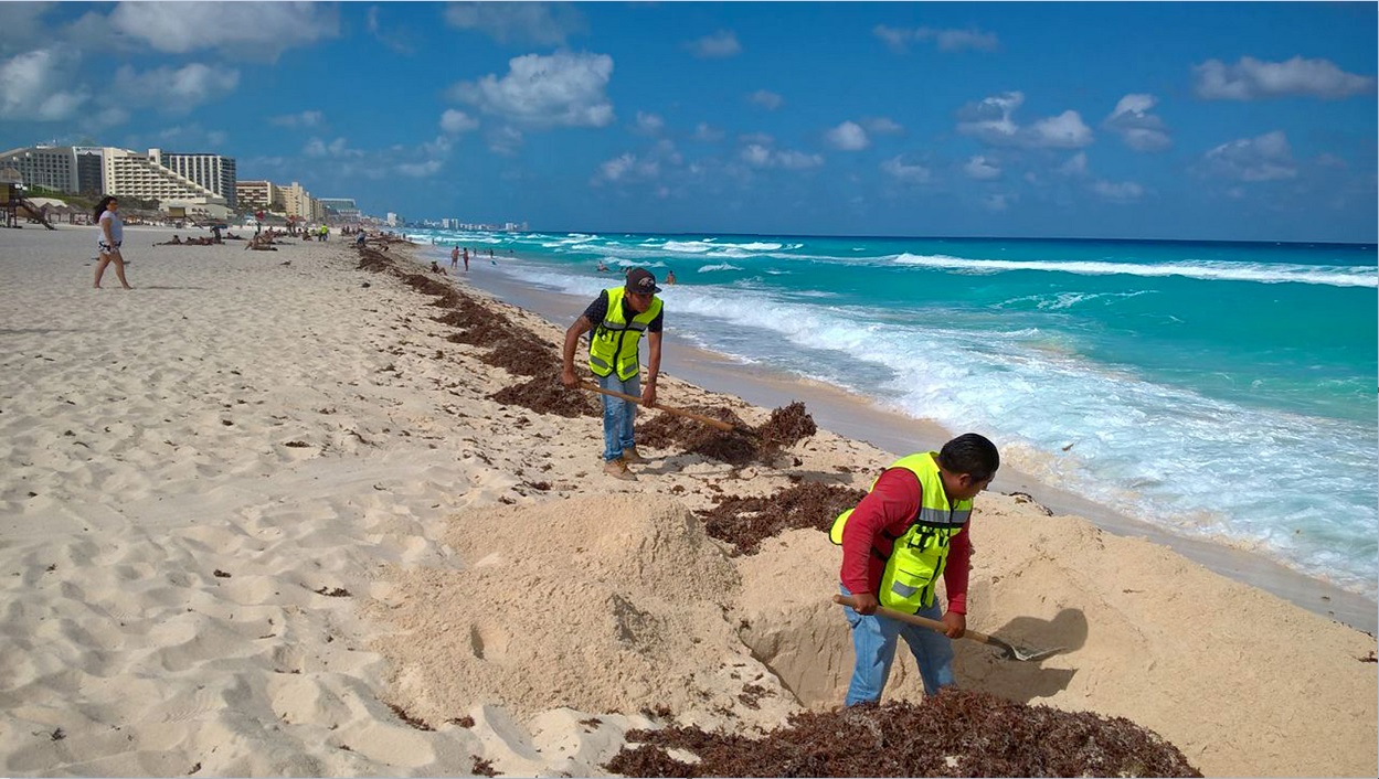 Trabajadores limpian arena en Cancún; la SCT informa que habrá vigilancia permanente en playas durante las vacaciones de Semana Santa (NTX, arhcivo)