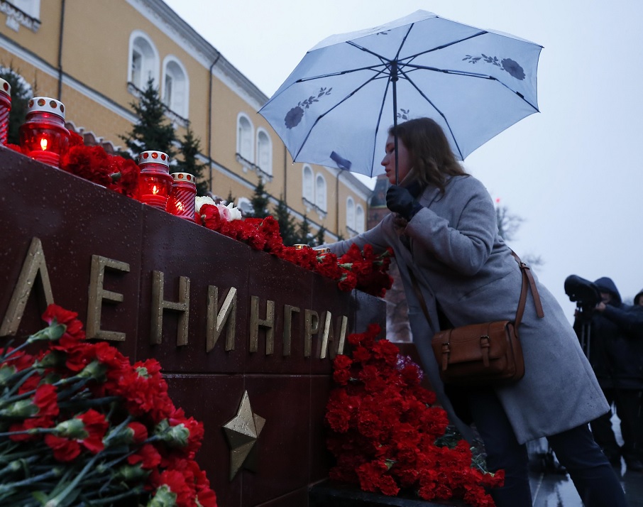 Una mujer pone flores durante un homenaje para las víctimas de la explosión en el metro de San Petersburgo (Reuters)