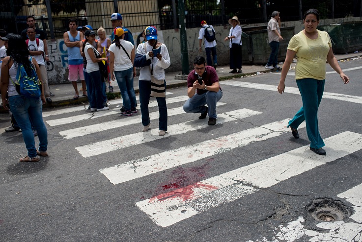 La mancha de sangre del joven de 17 años que resultó herido durante una concentración de la oposición en Caracas (EFE)