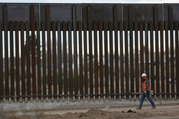 Un contratista camina por una sección construida de una valla fronteriza que separa a Estados Unidos y México en Sunland Park, Nuevo México (Getty Images/Archivo)