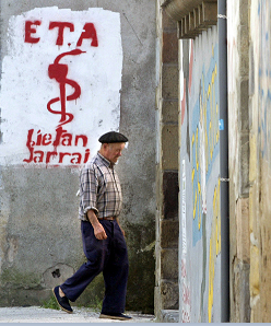 Un hombre camina frente a un graffiti que representa el logotipo del grupo separatista vasco ETA en Goizueta, España. (Reuters, archivo)