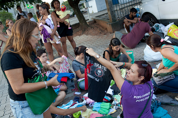Mujeres brasileñas obtienen ropa en tianguis
