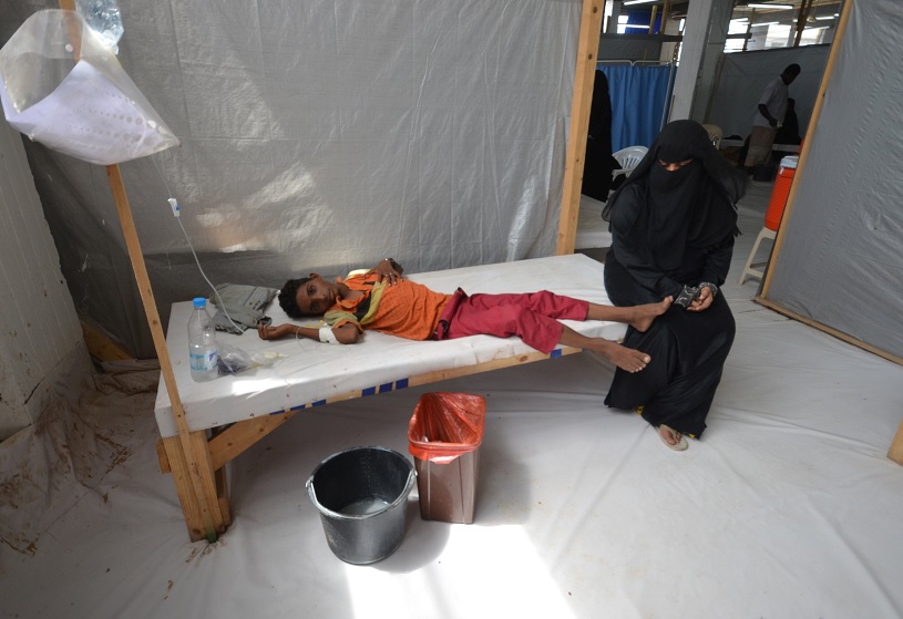 Una mujer se sienta al lado de su hijo infectado con cólera (Reuters)