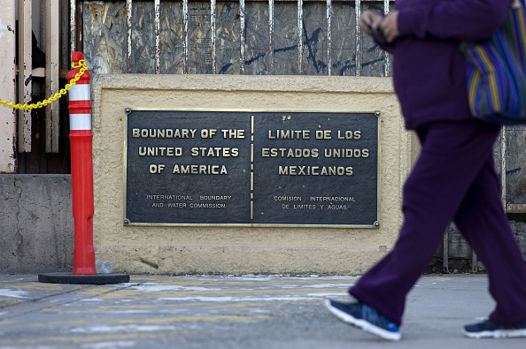 Una persona camina soreb la fronteta de Mexico y Estados Unidos
