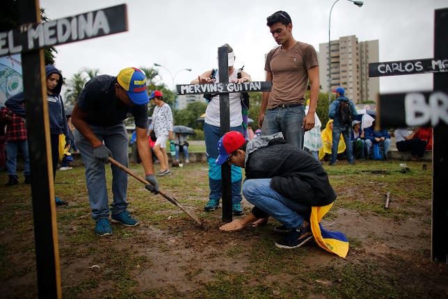 Manifestantes colocan cruces con los nombres de las personas que han muerto durante las protestas de la oposición en Caracas, Venezuela. (AP)
