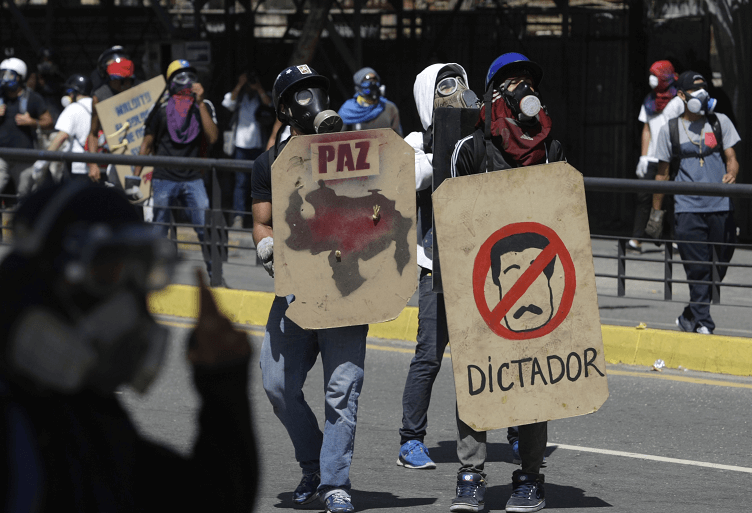 Opositores al gobierno de Maduro se protegen con escudos durante protestas en Caracas