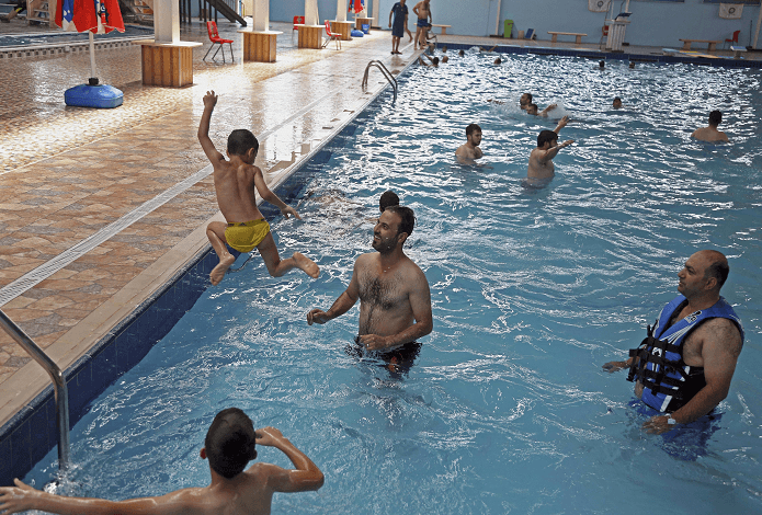 Personas nadando en una piscina en Irak