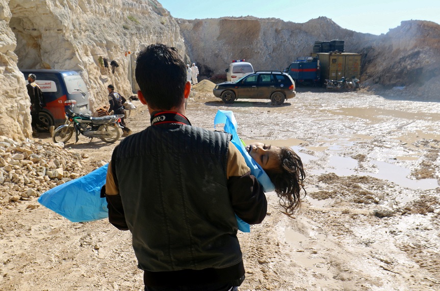 Un hombre carga el cadáver de un niño en Idlib, Siria (Reuters)