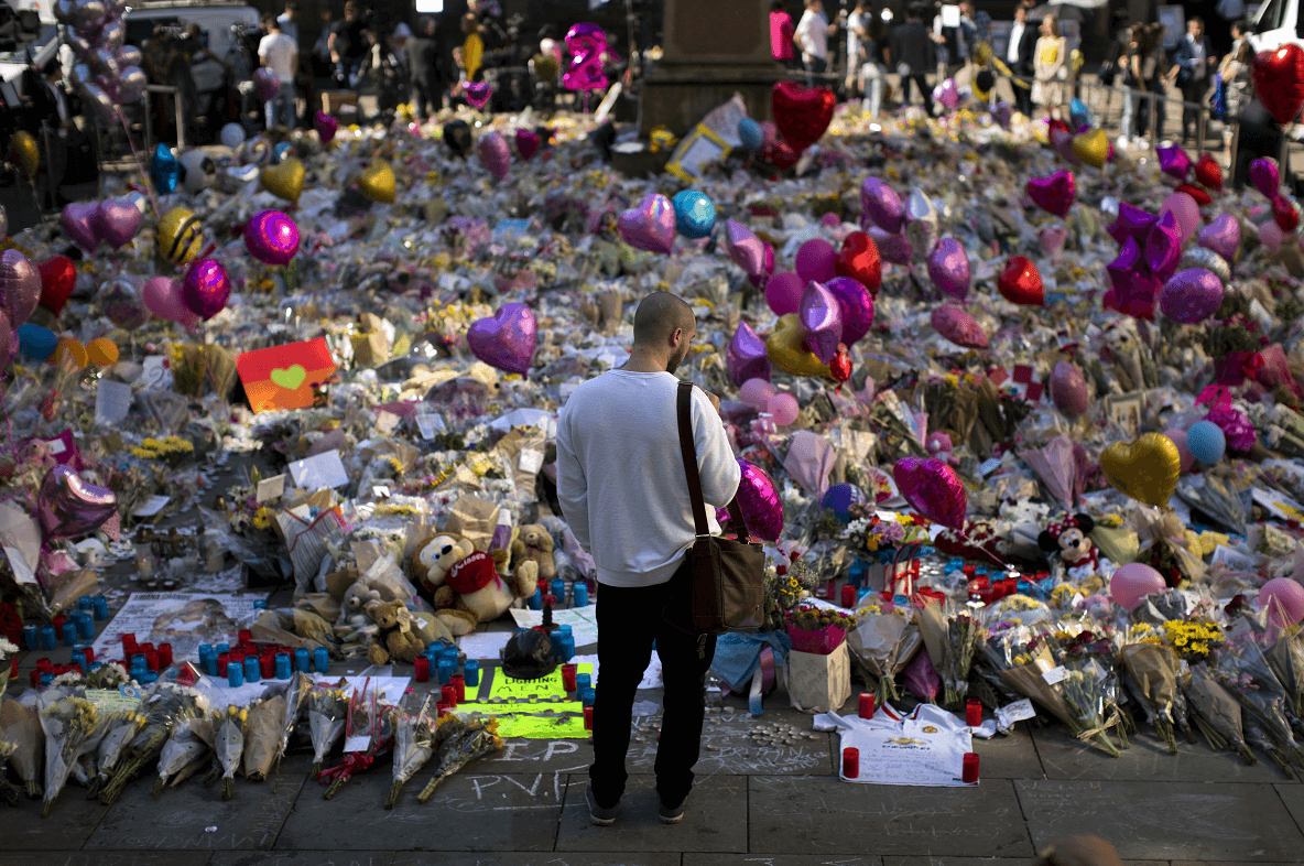 Un hombre observa las ofrendas dedicadas a las víctimas del atentado al Manchester Arena