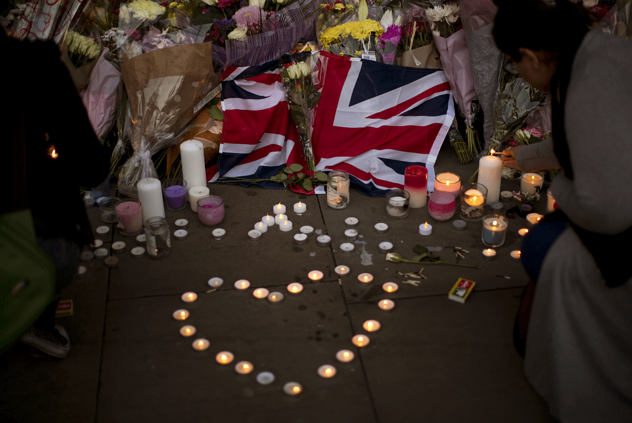 Una bandera británica luce enmedio de flores y velas en honor de las víctimas del atentado en el Manchester Arena