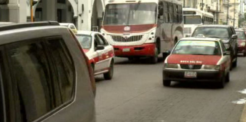 Autos y autobuses de transporte público circulan en calles de Veracruz
