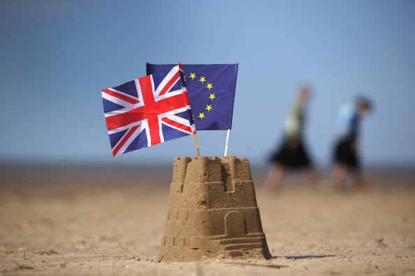 Banderas de Reino Unido y Union Europea sobre castillo de arena
