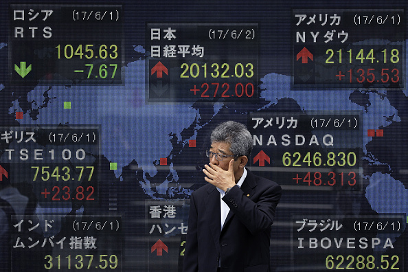 Un peatón pasa frente a un tablero de la Bolsa de Tokio