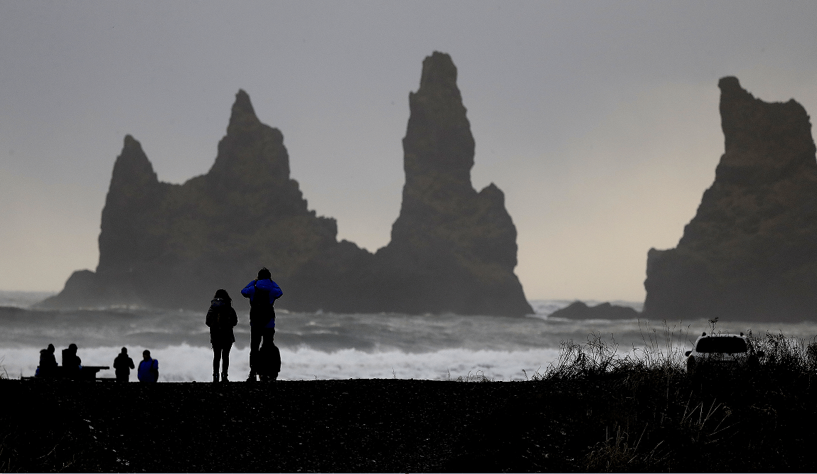 La gente camina en la playa negra en Vik, Islandia, cerca del volcán Katla