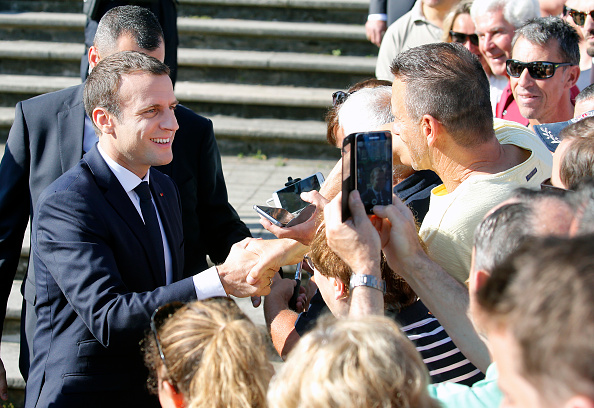 El presidente francés, Emmanuel Macron, da la mano a los simpatizantes a la salida de la mesa de votación (Getty Images)