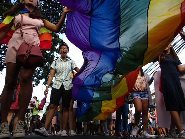Un grupo de personas extiende una bandera gay durante una marcha en Manila, Filipinas (Getty Images)