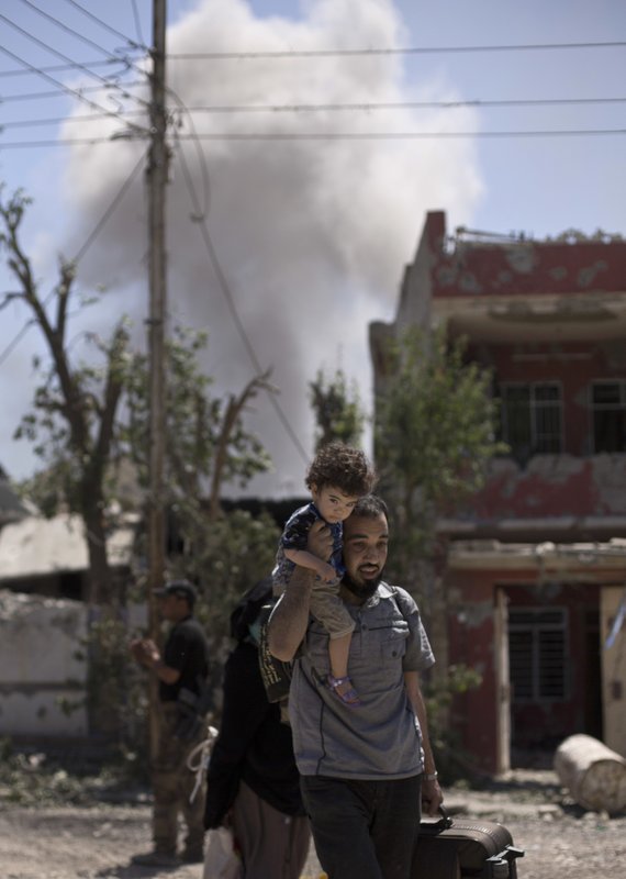 Nino es cargado por su padre en Mosul