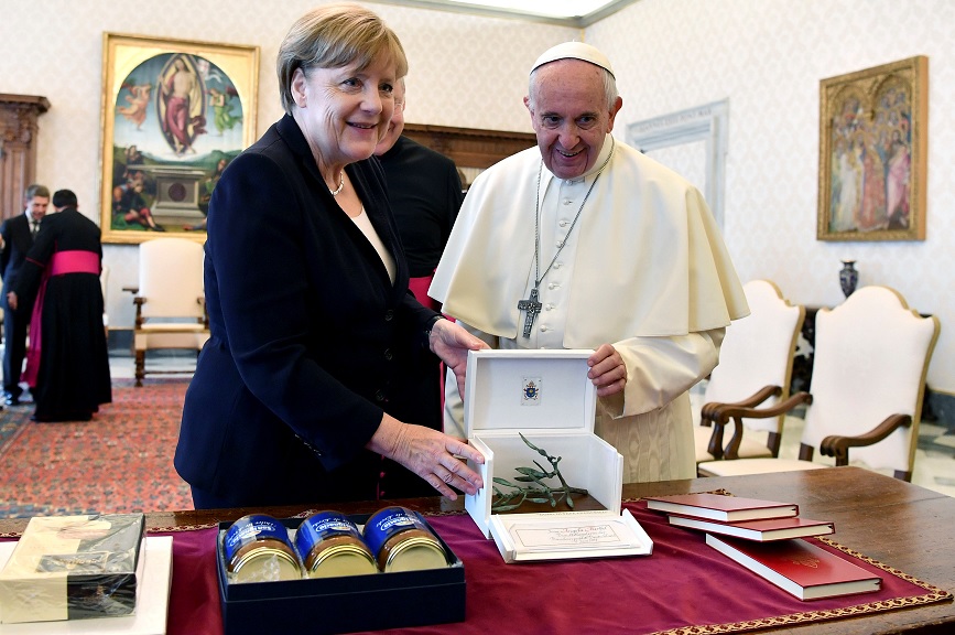 La canciller alemana Angela Merkel intercambia regalos con el papa Francisco durante una reunión en el Vaticano (Reuters)