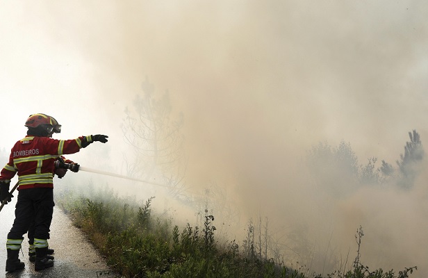Bomberos trabajan para extinguir un incendio en un bosque cerca de Cadafaz, Portugal (EFE)