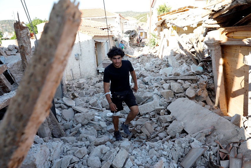 Los miembros del equipo de rescate buscan víctimas en un edificio derrumbado en el pueblo de Vrissa, en la isla griega de Lesbos (Reuters)