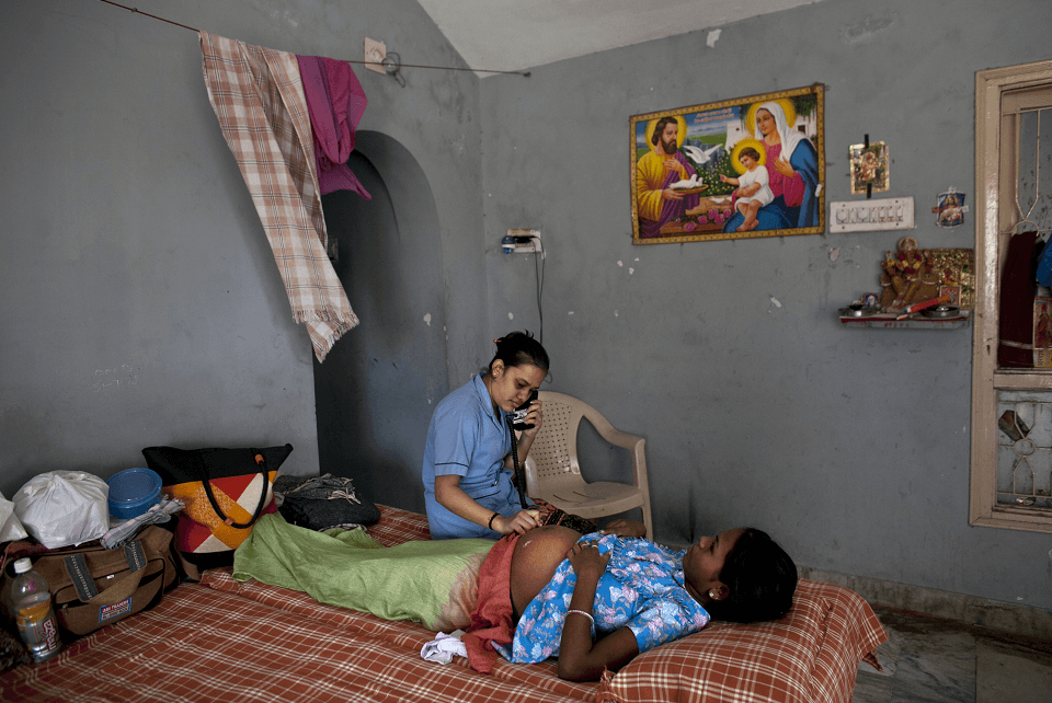 Una enfermera revisa a una mujer embarazada en la India