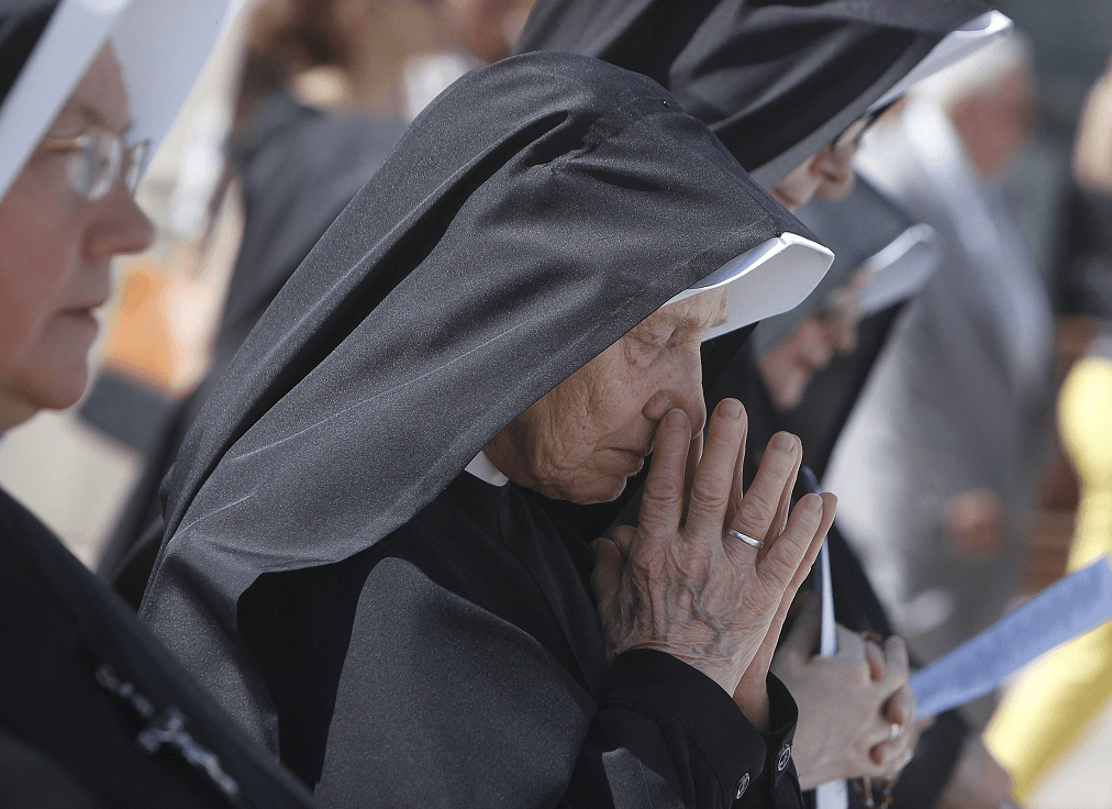 Una monja ora durante una procesión por el Jueves de Corpus Christi