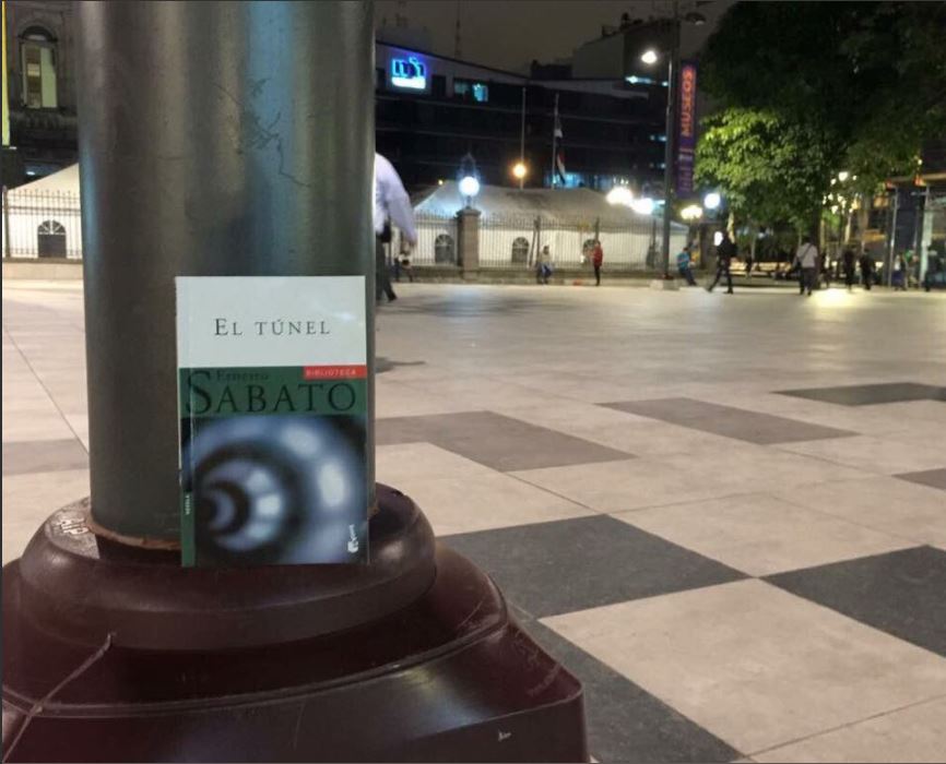 Una persona siembra un libro en una plaza publica