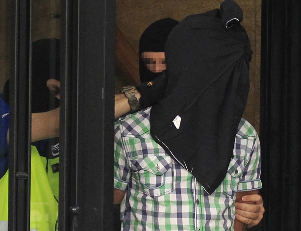 Agentes de la Policía Nacional trasladan a uno de los tres presuntos yihadistas marroquíes detenidos esta madrugada en Madrid (EFE)