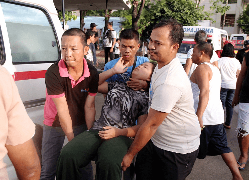 Ciudadanos filipinos socorren a una persona lesionada a causa del terremoto