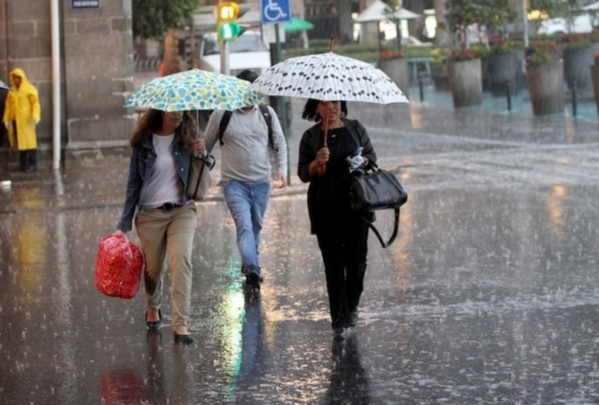 Foto: Dos mujeres se protegen de la lluvia, 14 julio 2019