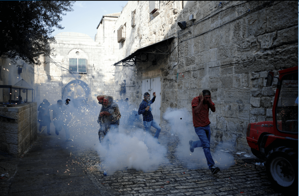 Palestinos corren luego de la explosión de una granada en la Explanada de las Mezquitas
